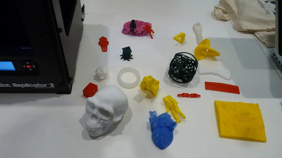 3D-gedruckte Teile in verschiedenen Farben und Materialien auf einem Tisch.