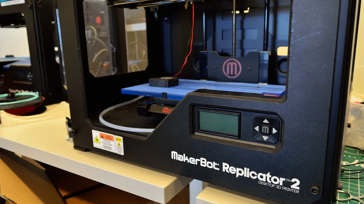 Close-up of a desktop 3D printer on a workbench.